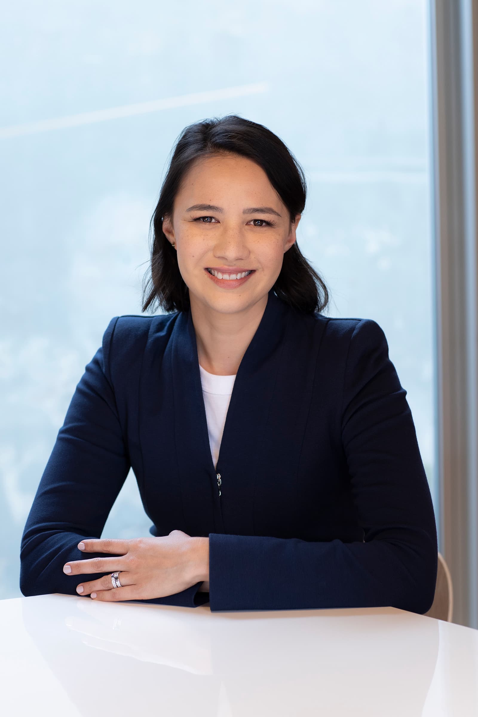 Professional portrait of a smiling woman in a navy blazer